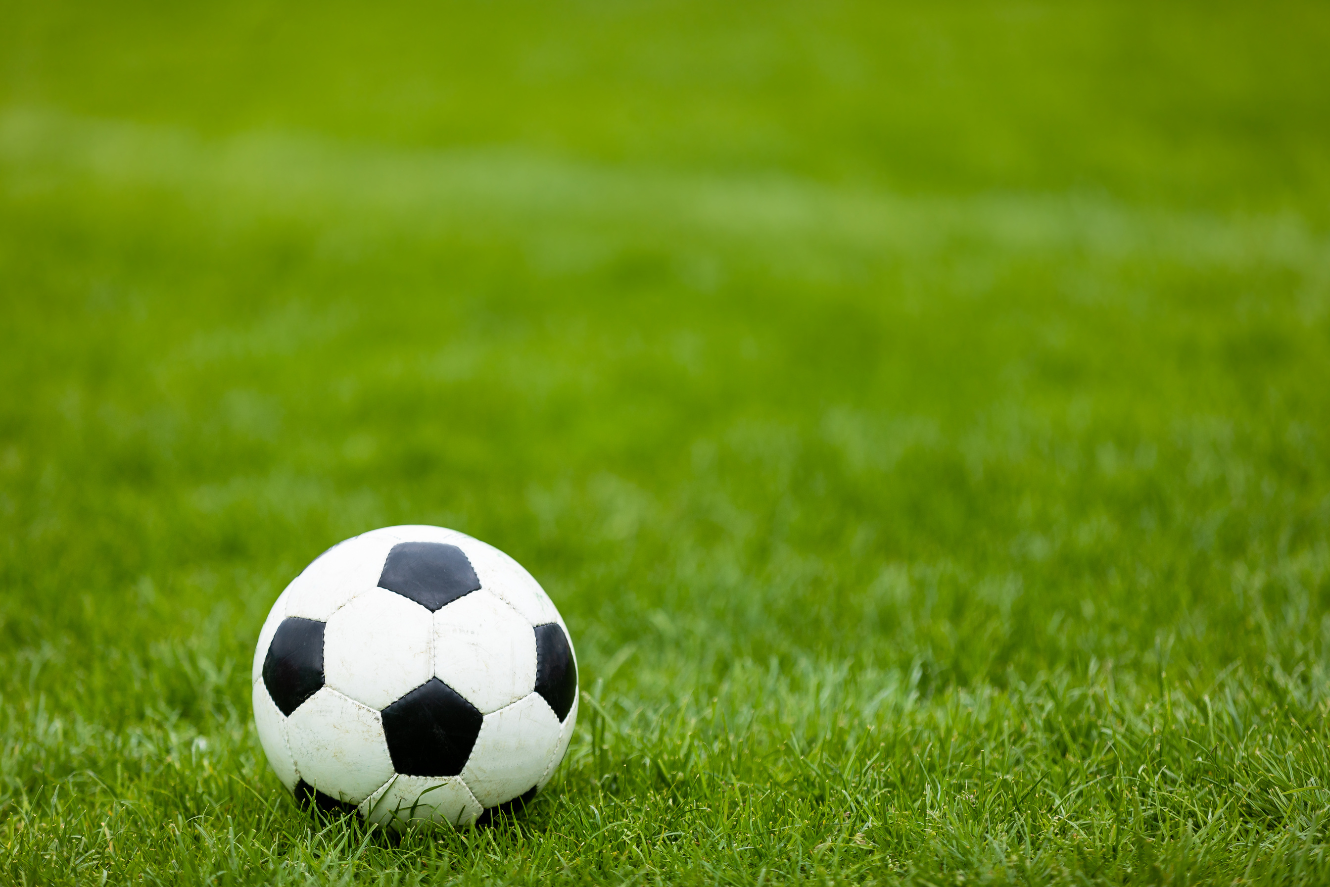 Soccer Football Ball on Soccer Field. Green Grass Soccer Pitch.